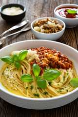 Spaghetti con ragù alla bolognese - pasta with minced meat and tomato sauce on wooden table	