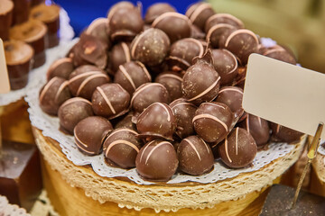 Pile of gourmet chocolate truffles on display at a market.
