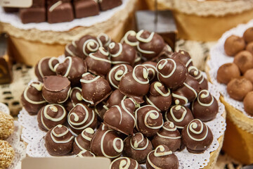 Gourmet chocolate candies with a decorative white swirl.