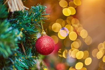 Red glitter Christmas ornament with a magical bokeh lights background.