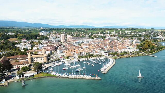 Aerial view of Morges Castle and harbor, where azure waters meet the quaint town with its terracotta rooftops, Morges, Vaud, Switzerland.