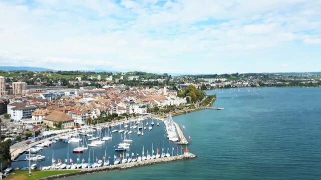 Aerial view of the marina filled with white sailboats docked at Lake Geneva with the city skyline in the background, Lake Geneva, Morges, Vaud, Switzerland.