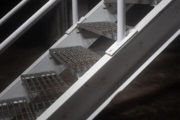 Obraz premium Iron stairway or walkway platform at the industrail workplace in night environment, horror or unsafe place. Close-up with selective focus.