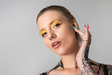 Obraz premium Stylish young woman with vibrant makeup making a bold fashion statement in a modern setting