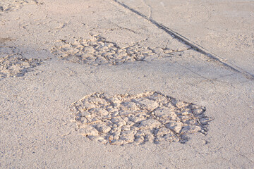 The old damaged street background with worn and broken texture on concrete road surface