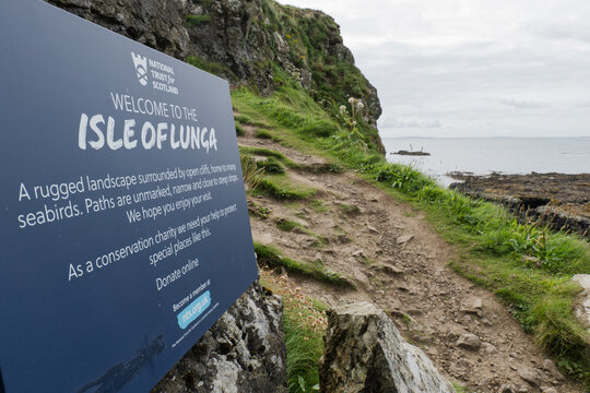 A welcomes sign on the Isle Of Lunga, part of the remote Treshnish Islands of the Inner Hebrides in Scotland. A rocky footpath leads visitors on to explore the island. Lunga, Scotland Jul 31 2025