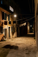 Quiet narrow street in Venice at night with hanging laundry, illuminated stone walkway, and old facades that reflect the timeless charm and cultural identity of the Italian city