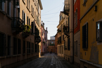 Charming Venetian passageway lined with traditional architecture and colorful walls, creating a tranquil cityscape that highlights the unique atmosphere of Venice, Italy