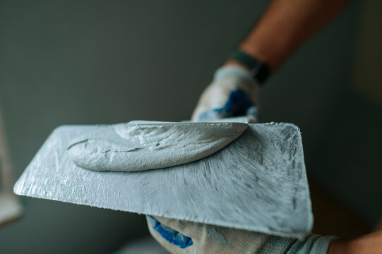 Close up of plastering work indoors with trowel and repair putty