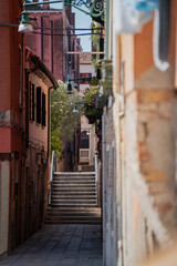 Picturesque old town passage in Venice with charming narrow street, historic textured walls, quiet staircase, Mediterranean atmosphere and authentic cultural travel setting