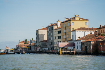 Picturesque Venice lagoon view with rustic houses, pastel facades, historic waterfront architecture and cultural charm of Italian coastal cityscape under clear sky