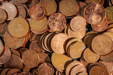 Pile of euro cent coins in various denominations, showing copper and brass tones, symbolizing small change, currency circulation, and everyday transactions.