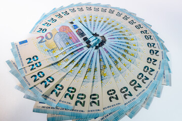 Circular arrangement of 20 euro banknotes spread out like a fan on a white background, symbolizing finance, savings, and monetary wealth.