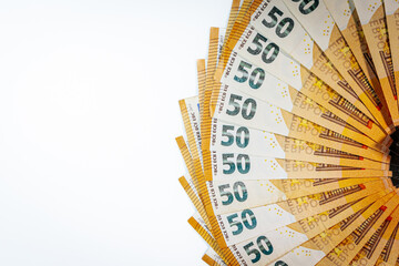 Fanned out stack of 50 euro banknotes arranged in a semi-circle on a white background, symbolizing...