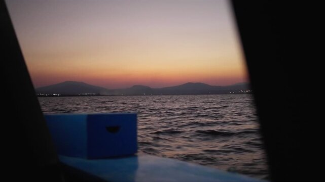 Slow motion PoV shot of Paztcuaro lake at sunset from a boat