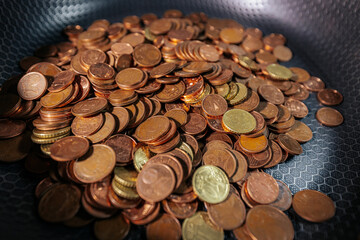 A frying pan filled with euro cent coins, symbolizing money, savings, financial struggles, or the...
