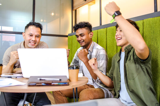 Happy Asian Men Celebrating Successful Project, Looking at Laptop and Raising Their Fists - Powered by Adobe