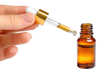 Hand holding dropper bottle, amber liquid drips