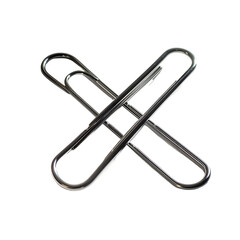 Two metallic paperclips interlocked forming an 'X' shape against a black background