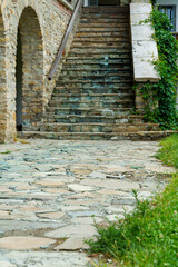 view of stone steps of an old house with arches and porch