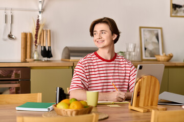 Young man engaged in online study from a modern apartment during the day