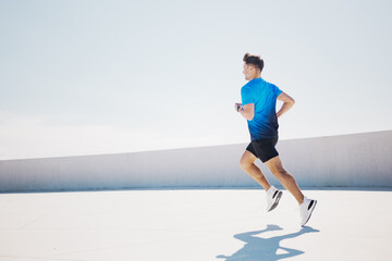Man runs on rooftop terrace in bright blue sportswear and athletic shoes
