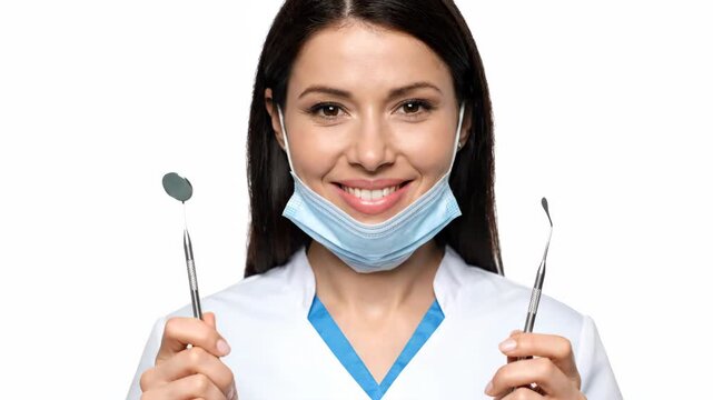 Smiling Dentist Woman Holding Tools With Mask Pulled Down In Office Setting
