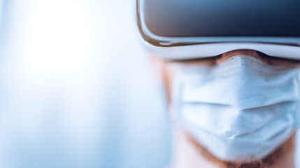 Person wearing virtual reality headset and medical face mask, close-up view