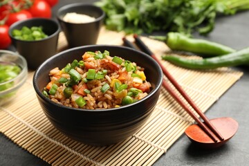 Delicious fried rice in bowl served on grey table, closeup