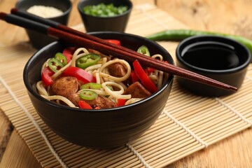 Tasty noodles with chicken and vegetables served on wooden table, closeup