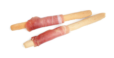 Delicious grissini sticks with prosciutto isolated on white, top view