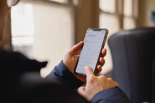 hand using smartphone with calendar app on screen. Concept of time management, planning, scheduling, productivity, digital organizer, business reminder modern lifestyle efficiency.