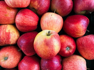 A top view photo of ripe apples neatly arranged and filling the entire frame. The apples create a colorful food background, perfect for themes of health, nutrition, farming, and seasonal harvest.