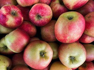 A top view photo of ripe apples neatly arranged and filling the entire frame. The apples create a colorful food background, perfect for themes of health, nutrition, farming, and seasonal harvest.