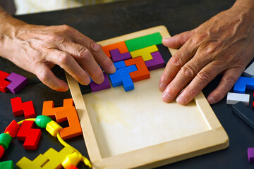 Hand arranging colorful puzzle blocks for mental health therapy