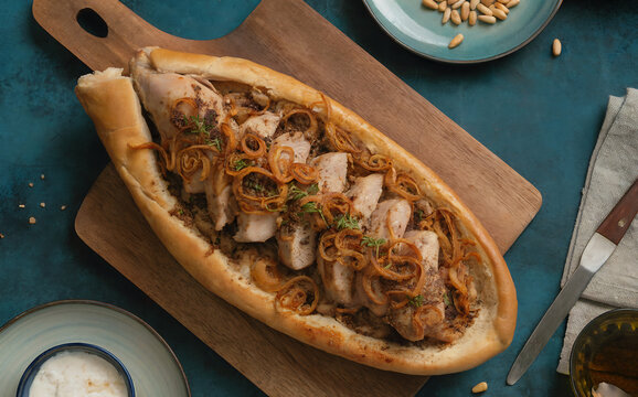 Musakhan. Baked chicken on tabun bread, topped with fried sweet onion pieces, sumac, allspice, and pine nuts.
