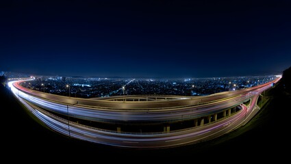 Night cityscape with highway interchange showing light trails and city illumination 90