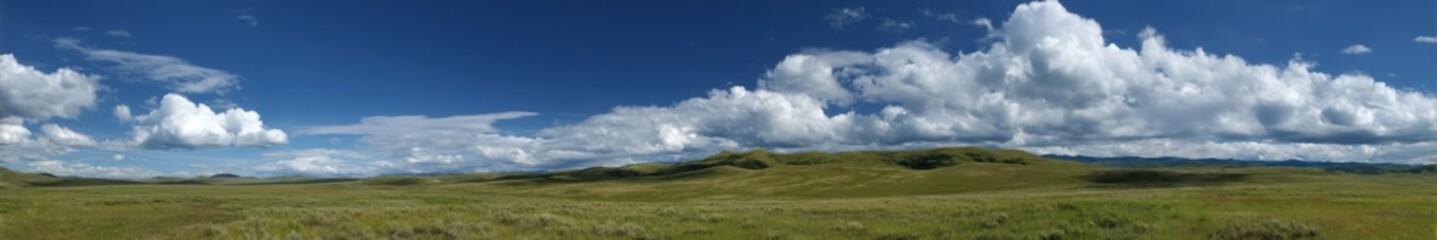 Vibrant hdr panorama of rolling green hills under blue sky nature landscape
