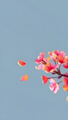 Pink cherry blossoms against a soft blue sky with falling petals in springtime air