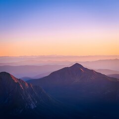 Beautiful mountain range at sunset with hazy layers and soft pastel color gradient sky