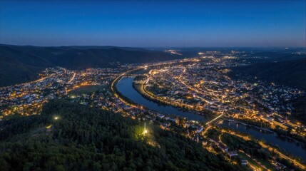 Aerial view of a cityscape illuminated at night with a winding river passing through it offering a