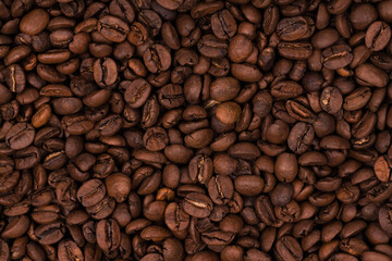 Freshly roasted coffee beans background texture. Close-up, top view.