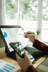 Businessperson analyzing financial charts with laptop and documents, symbolizing data analysis,...