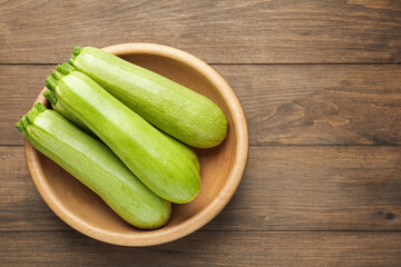 Fresh ripe zucchinis on wooden table, top view. Space for text