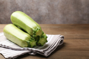 Fresh ripe zucchinis on wooden table, closeup. Space for text