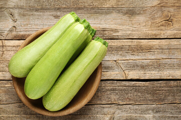 Fresh ripe zucchinis on wooden table, top view. Space for text
