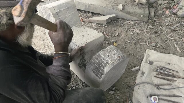 Stone Carving - Stone Art in India. Indian stone mason Creating abstract sculpture Of granite Stone. Cutting rock with grinder, chisel and hammer with traditional technique. Slow Motion 4k Footage