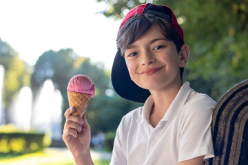 Summer childhood vacation, happy boy eating ice cream near fountain, kids leisure and holiday rest outdoors, child enjoying sweet dessert in sunny park