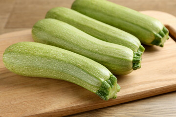 Fresh ripe zucchinis on wooden table, closeup