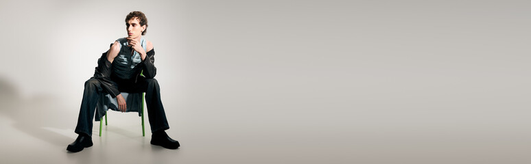 Handsome man showcasing modern elegance in a stylish pose during a fashion themed event